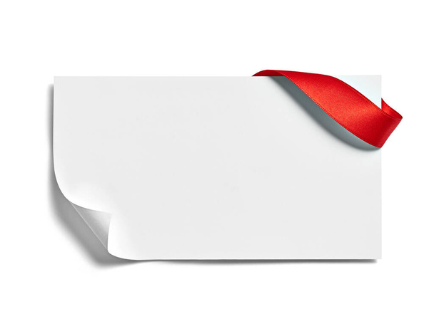 close up de um cartão de nota com laço de fita vermelha no fundo branco - Foto, Imagem