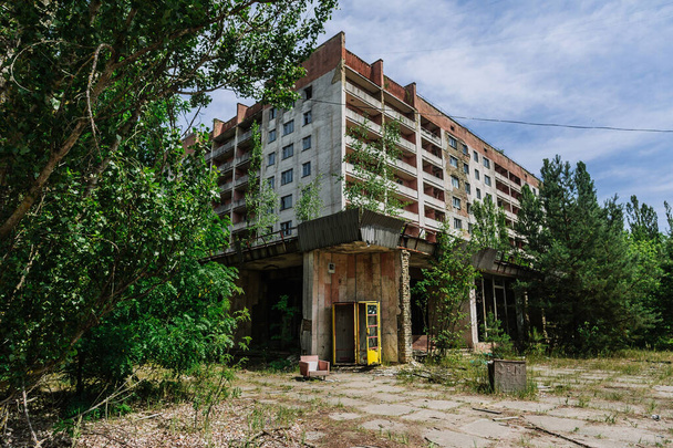 Phone box near abandoned building in centre of ghost town Pripyat Chornobyl Zone, radiation, nuclear catastrofe - 写真・画像