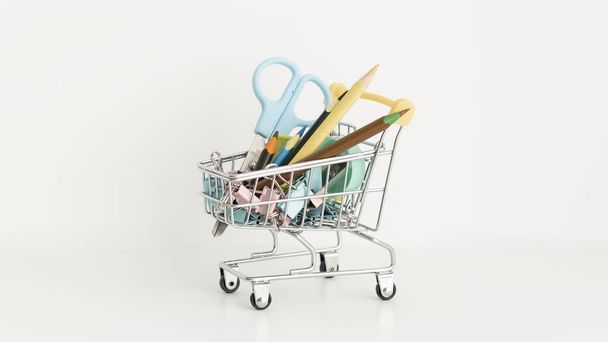 Trolley with school equipment on white background - Fotó, kép