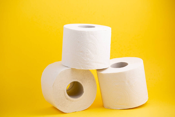 Duży biały rolka papieru toaletowego do stosowania w łazienkach lub kuchniach, używany do czyszczenia brudu w łazience na żółtym tle - Zdjęcie, obraz