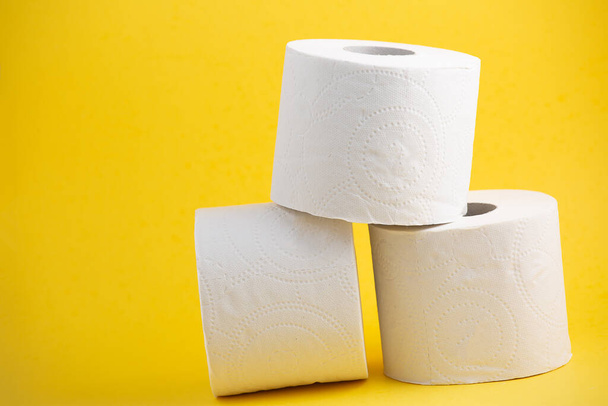 Velký bílý toaletní papír role pro použití v koupelnách nebo kuchyních, používané pro čištění nečistot v koupelně na žlutém pozadí - Fotografie, Obrázek