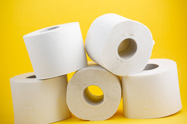 Velký bílý toaletní papír role pro použití v koupelnách nebo kuchyních, používané pro čištění nečistot v koupelně na žlutém pozadí - Fotografie, Obrázek