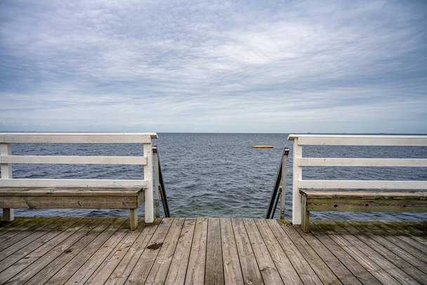Drewniany pomost z błękitnym oceanem i niebem w tle. Zdjęcie z Malmö, Szwecja - Zdjęcie, obraz