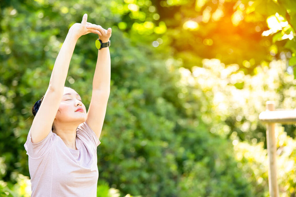 nuori aasialainen nainen tekee jooga fitness harjoituksia luonnonpuistossa, Liikunta terveyden tai lämmin elin, raitista ilmaa tai happea vihreässä puussa puistossa auringonvalossa. - Valokuva, kuva