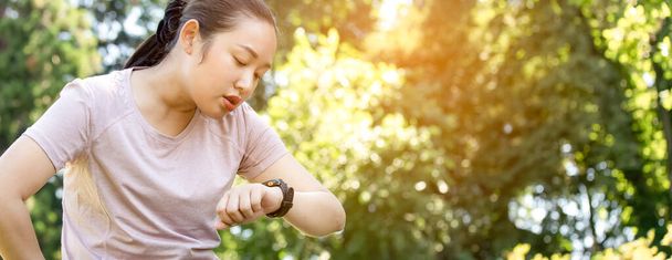 Young Asian woman doing running exercises in the nature park, Exercise for health or warm-up body, fresh air, or Oxygen in the green tree in the park in sunlight. - Photo, Image