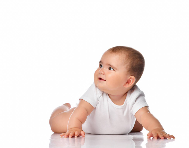 Smiling baby kid creeping on white studio floor - Photo, Image