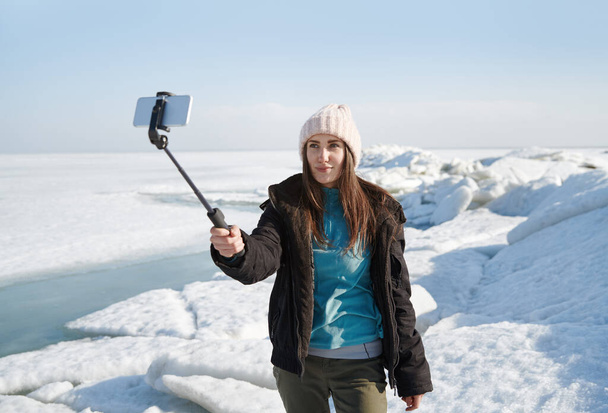 Reiserin an der Jokulsarlon Glacial Lagoon macht Selfie mit Einbeinstativ - Foto, Bild