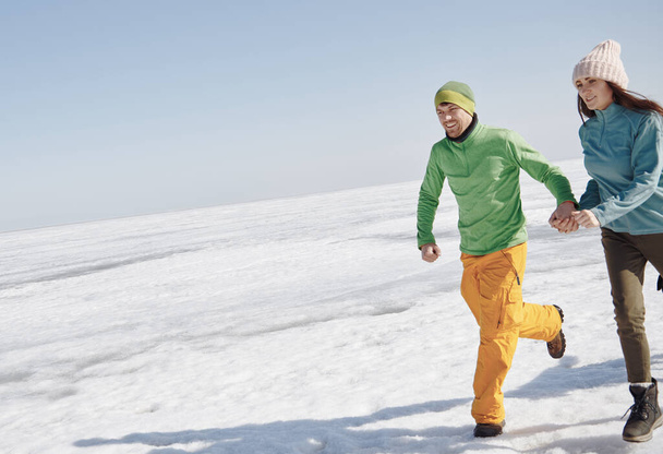 Молода доросла пара на відкритому повітрі біжить в зимовому пейзажі
 - Фото, зображення