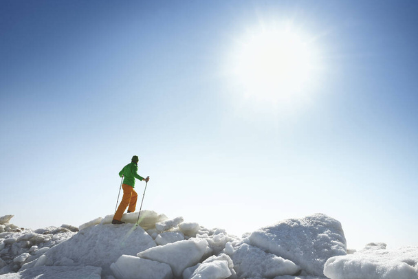 Fiatal felnőtt férfi szabadban sétapálcával felfedező jeges táj - Fotó, kép