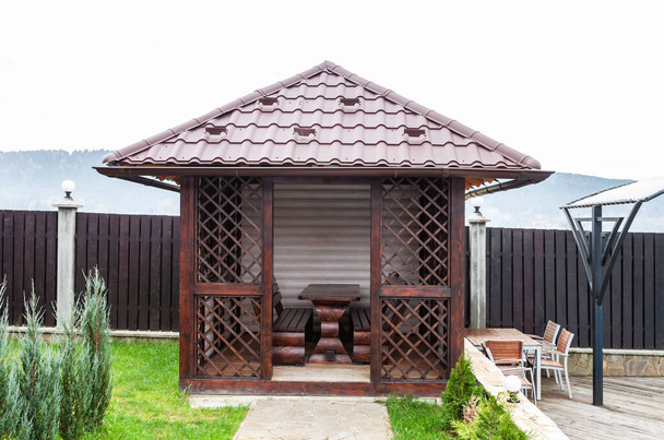 Casa jardín de madera para relajarse, techo de baldosas de metal - Foto, imagen