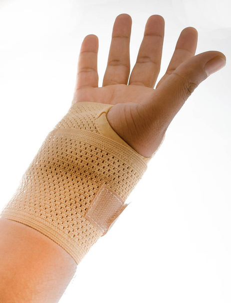 Eine Hand mit einem Handgelenkgürtel auf isoliertem weißem Hintergrund. - Foto, Bild