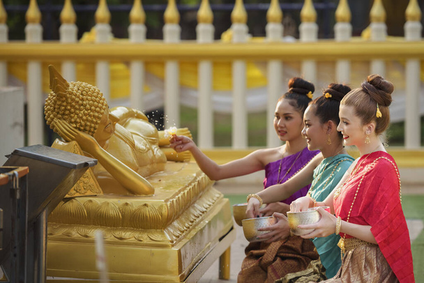Тайские девушки и девушки лаоса плеск воды во время фестиваля Сонгкран, Церемония освящения воды взрослых, Будда статуя воды церемонии в Сонгкран фестиваль, Таиланд традиционные. - Фото, изображение