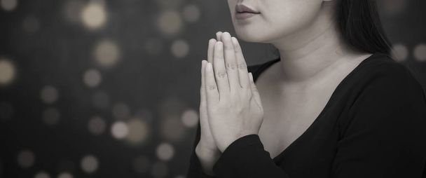 Asiatique visage femme prier et adorer à DIEU En utilisant les mains pour prier dans les croyances religieuses et adorer chrétien dans l'église ou dans les endroits généraux en arrière-plan blanc et noir - Photo, image