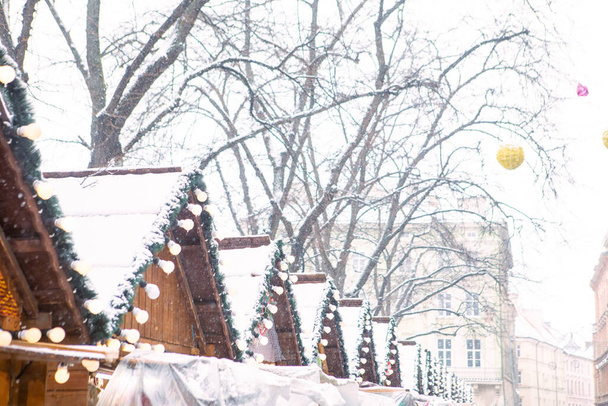 Şehir meydanındaki Noel köyünün karlı çatılarının görüntüsü - Fotoğraf, Görsel
