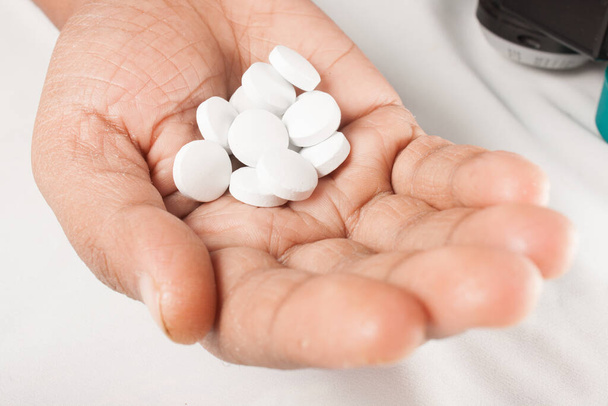 Una imagen que muestra pastillas en la mano de los pacientes sobre un fondo aislado. - Foto, Imagen