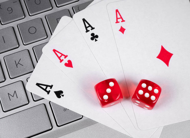 Online-Casino. Karten und Würfel stapeln sich auf einem Laptop - Foto, Bild