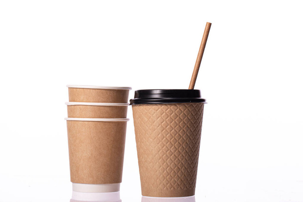 Élégantes tasses en papier brun jetables petites et moyennes tailles sur fond blanc - Photo, image