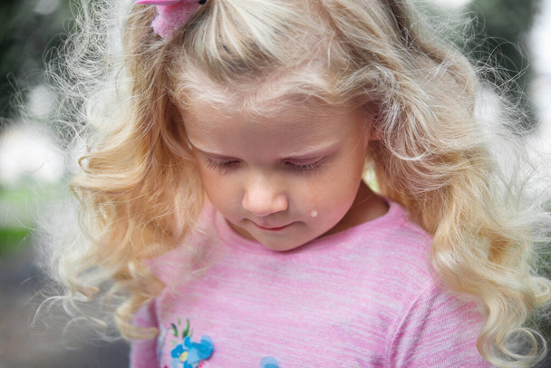 маленька дівчинка з кучерявим світлим волоссям на прогулянці, літній день
 - Фото, зображення