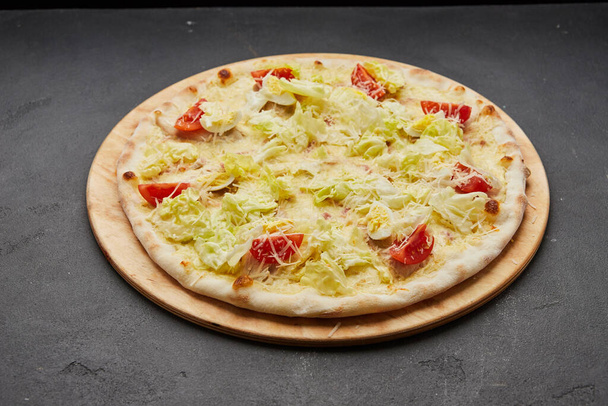 Heerlijke Italiaanse pizza Caesar op donkere achtergrond - Foto, afbeelding
