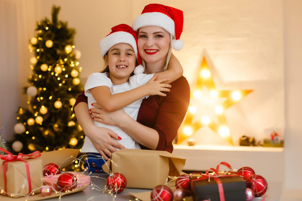 vacaciones, regalos, navidad, x-mas, concepto de cumpleaños - madre feliz y niña con caja de regalo - Foto, imagen