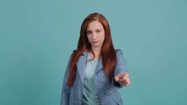 Upset woman that showing no with her finger posing on turquoise background. - Footage, Video