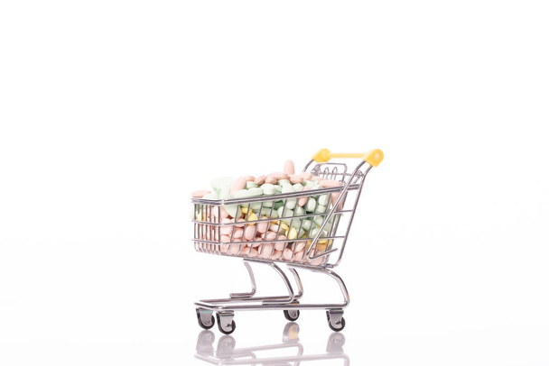 Carro de la compra lleno de medicamentos aislados sobre fondo blanco. Asistencia sanitaria - Foto, imagen
