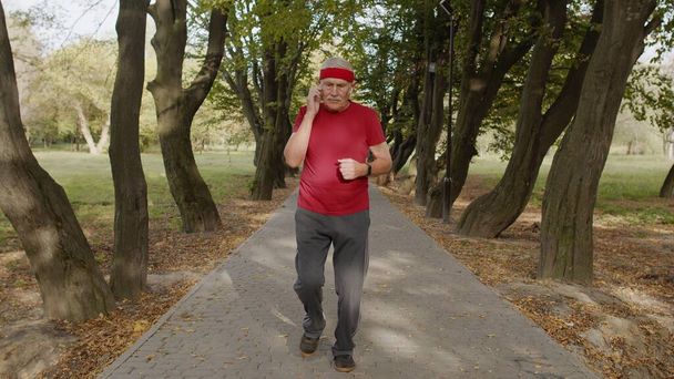 高齢者スポーツランナーの男のトレーニング。朝公園の外で心臓を働かせなさい。現役の先輩方 - 写真・画像