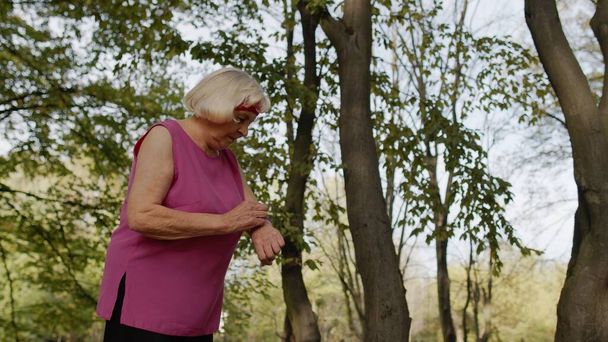 Donna anziana corridore sportivo utilizzando smart watch toccando touchscreen, risultato di monitoraggio. Allenamento fitness - Foto, immagini