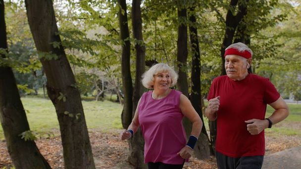 Sportlich reifes Familienpaar beim gemeinsamen Joggen. Senior Mann und Frau machen Cardio-Workout-Übungen - Foto, Bild
