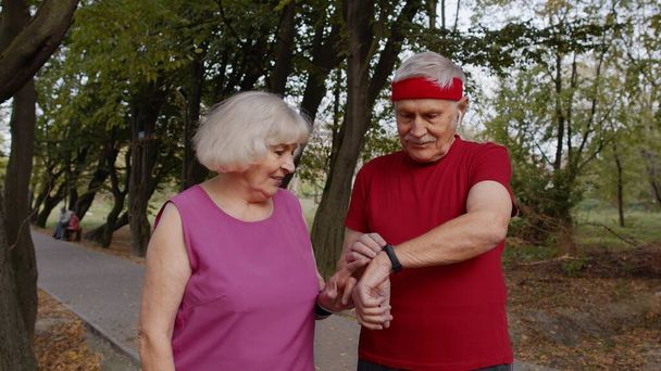 Ältere Familie Paar zusammen nach dem Laufen mit Smart Watch, Tracking-Ergebnis von Fitness-Training - Foto, Bild