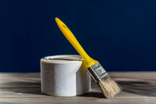 Beyaz boya ve boya fırçası. Örtülü ahşap tahta - Fotoğraf, Görsel