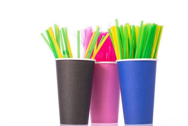 Pajitas para beber de plástico de colores en vasos desechables aislados sobre fondo blanco - Foto, Imagen