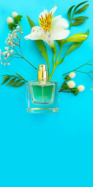 fles parfum, bloem op een gekleurde achtergrond - Foto, afbeelding