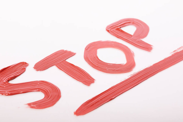Acrylic red stop lettering on white background. Stop discrimination, violence - Photo, Image