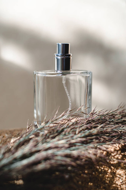 Botella de perfume de hombre sobre fondo claro con sombras - Foto, Imagen