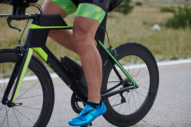 крупним планом спортсмен триатлону їзда на професійному гоночному велосипеді на тренуваннях
 - Фото, зображення