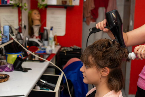 Menina adolescente bonita no golpe cabeleireiro secando seu cabelo depois de cortá-lo - Foto, Imagem
