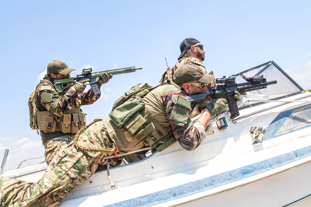 Soldados de los SEALs de la Marina persiguiendo enemigos en lancha rápida - Foto, imagen