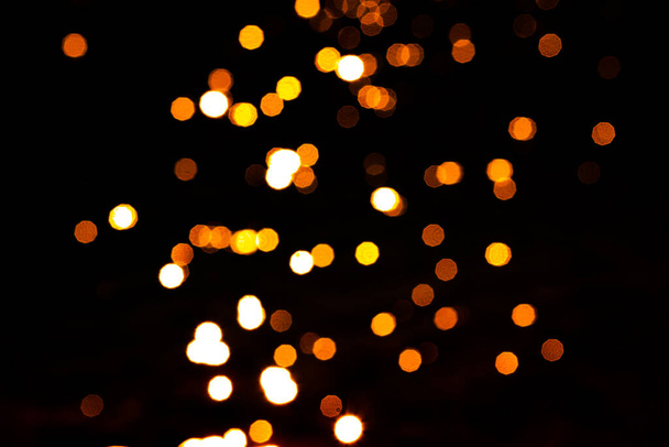 Pomarańczowy i żółty bokeh. Piękne rozproszone tło światła. Światła i uroczystości Bożego Narodzenia. - Zdjęcie, obraz