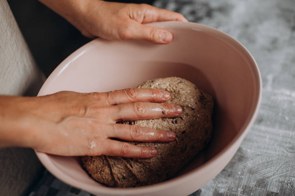 female hands kneading dough for homemade bread in a bow - Foto, immagini