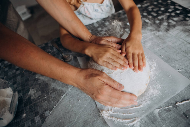 homemade bread cooking on the table kitchen hands of mom and daughter together - Foto, Bild