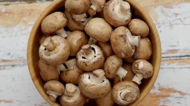 Fresh mushrooms in wooden bowl placed on white wooden table - Footage, Video