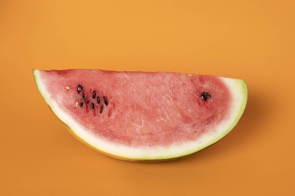 closeup part of refreshing watermelon on orange background - Valokuva, kuva