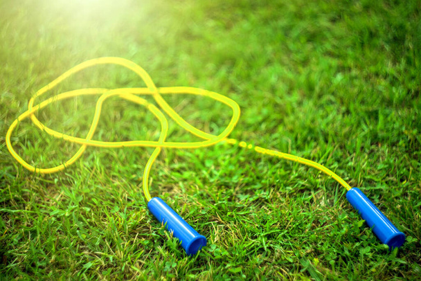 Jump rope on a green summer background - Foto, Imagen