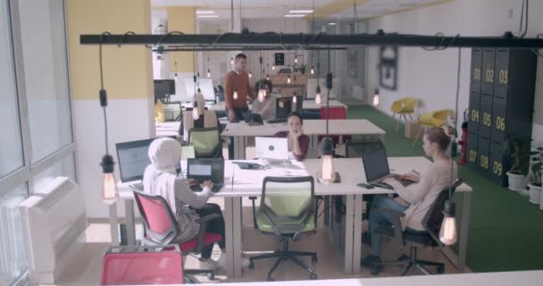 Jeunes de diverses origines ethniques travaillant dans un bureau moderne de coworking pendant la journée - Séquence, vidéo