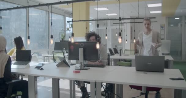 Молодые люди разных национальностей, работающие в современном офисе днем - Кадры, видео