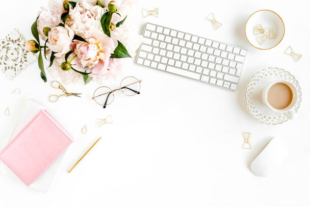 Flat lay womens office desk. Female workspace with computer, pink peonies bouquet, accessories on white background. Top view feminine background. - Foto, Imagen