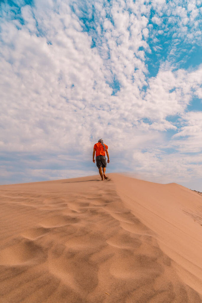 A man with a red shirt and a turban on his head, walking in the desert of the dune of Playa de Mnsul in the natural park of Cabo de Gata, Nijar, Andalucia. Spain, Mediterranean Sea - Fotó, kép