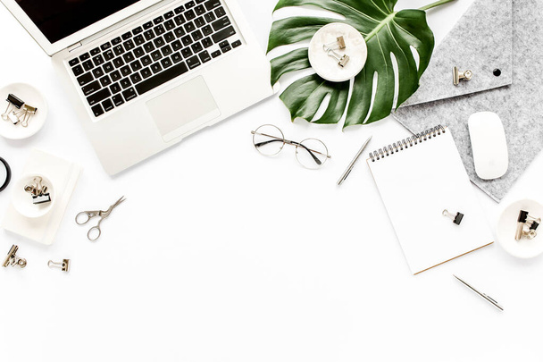 Home office workspace mockup with laptop, tropical leaves Monstera, clipboard, notebook and accessories on white background. Flat lay, top view - Φωτογραφία, εικόνα