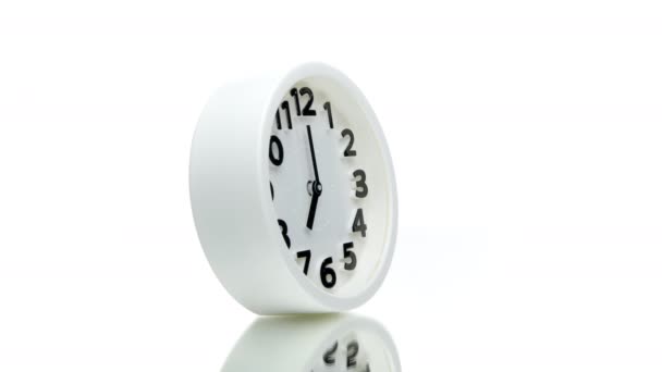 白に隔離された回転360回転する7つの時計を示す白い目覚まし時計 - 映像、動画